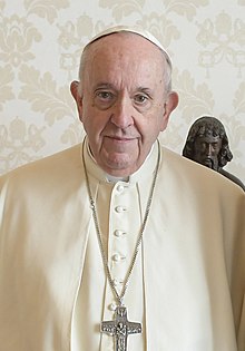 Papst Franziskus, der 266. Papst der römisch-katholischen Kirche, in einem feierlichen Moment. Er trägt die traditionelle weiße Papstkleidung und ein Kreuz auf der Brust. Dieses Bild zeigt seine demütige und freundliche Ausstrahlung, die seine Hingabe an den christlichen Glauben und den Dienst an der Kirche widerspiegelt.
